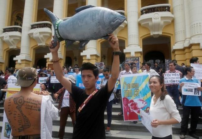 Demonstrators, holding signs of environmental-friendly messages, say they are demanding cleaner waters in the central regions after mass fish deaths in recent weeks, in Hanoi, Vietnam
